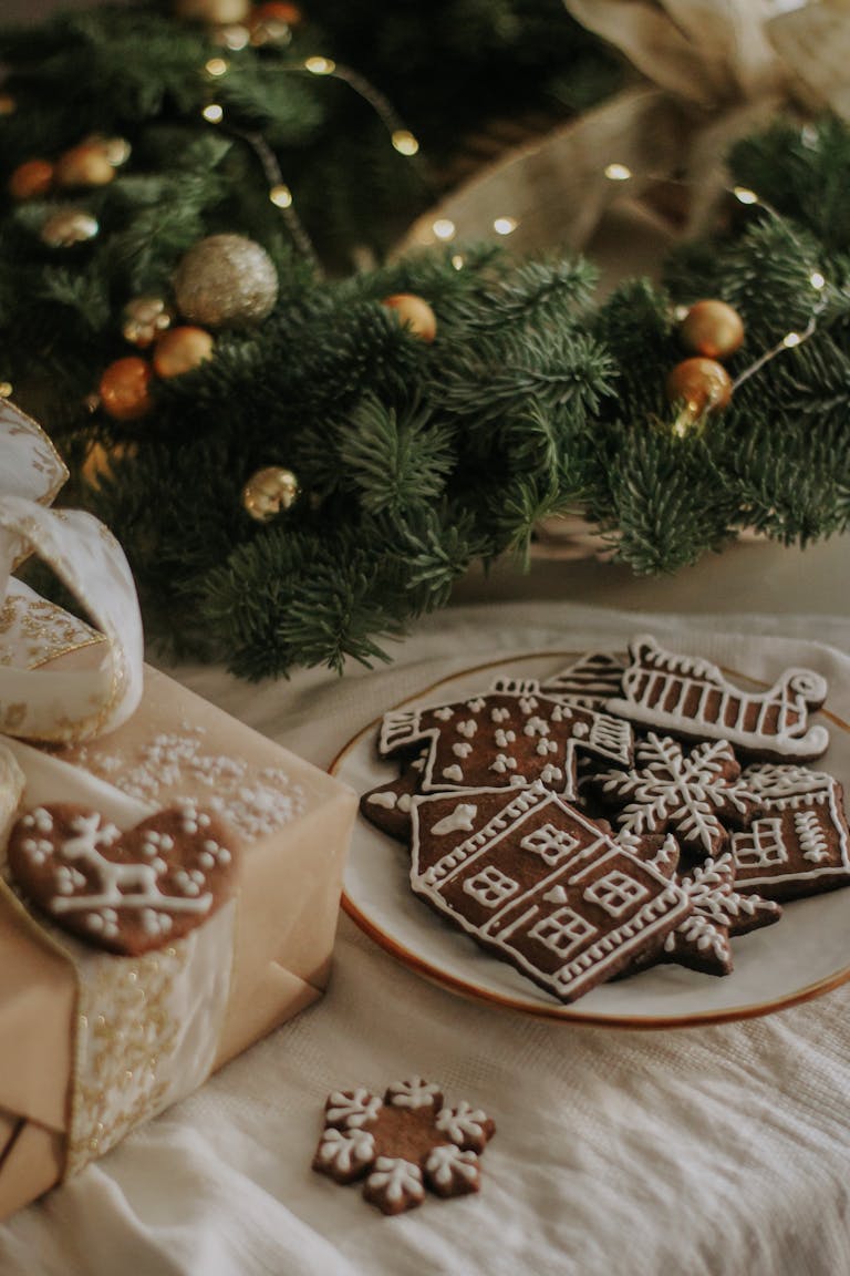 A cozy display of gingerbread cookies with icing amidst holiday decor and gifts.