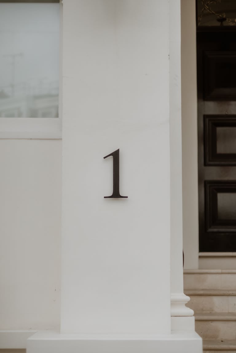 Close-up of a London home's exterior featuring number 1 on a white column.